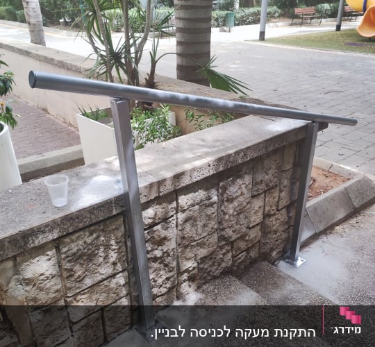 מעקה מתכת מותקן על מדרגות אבן